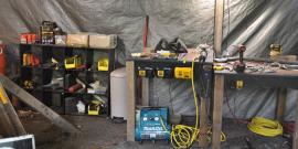 A well-appointed workshop complete with shelves, worktables, cordless power tools, and a Makita quiet series air compresser that was rescued from a dumpster and repaired.